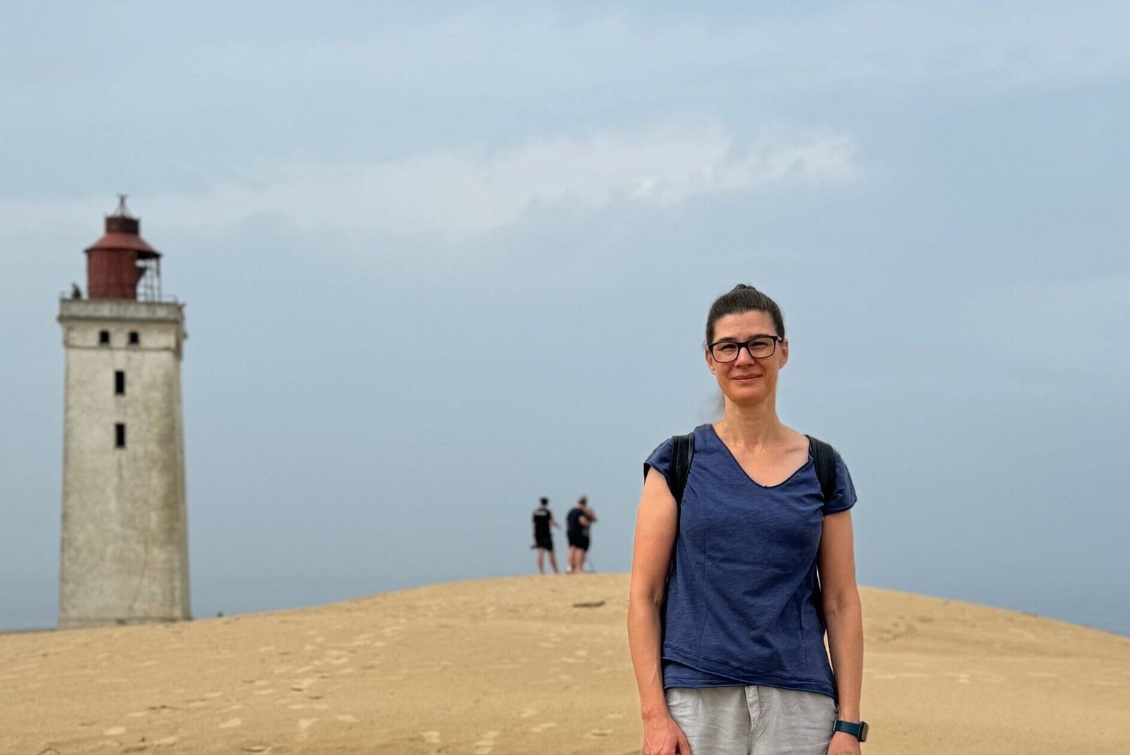 Katharina Bötel auf einer Düne vor einem Leuchtturm