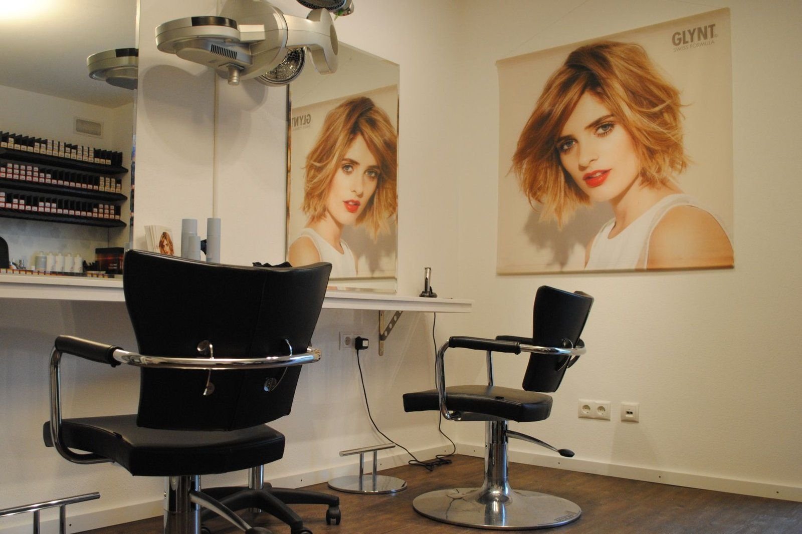 Blick in den Salon mit zwei Friseurstühlen vor dem Spiegel